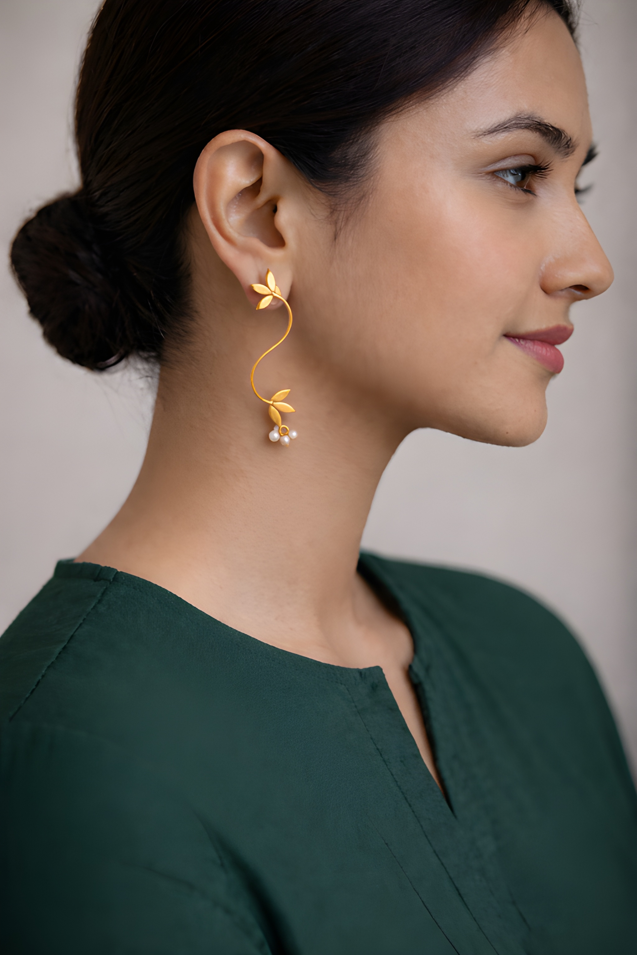 Woman wearing S-shaped vine curve earrings with flowing leaf design
