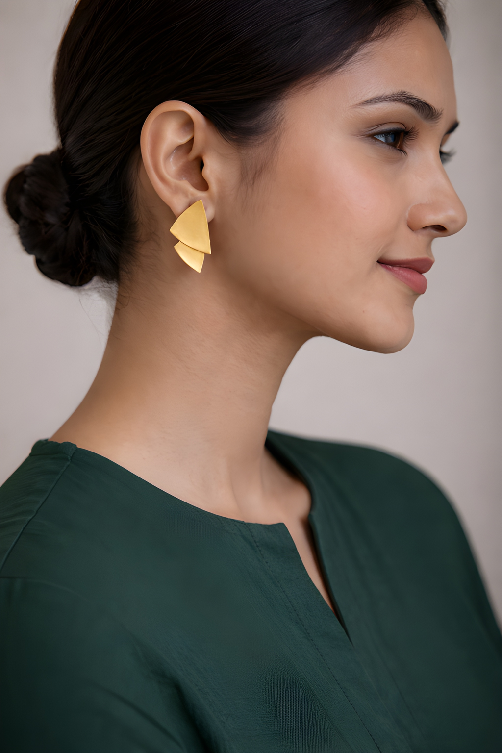 Woman wearing matte gold leaf stud earrings
