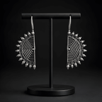 Oxidised half-moon maze earrings displayed on black stand
