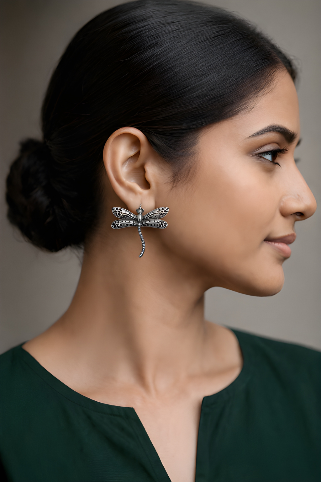 Woman wearing oxidised silver dragonfly stud earrings
