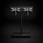 Dragonfly stud earrings displayed on black stand
