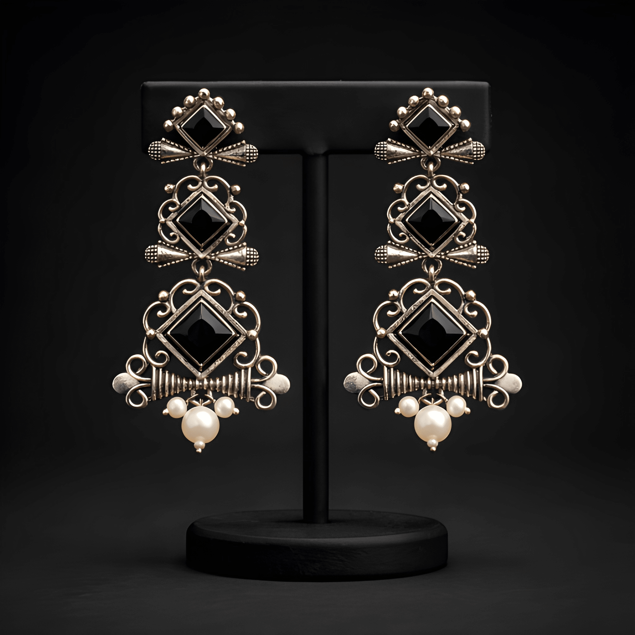 Multi-tier chandelier dangler earrings displayed on black stand
