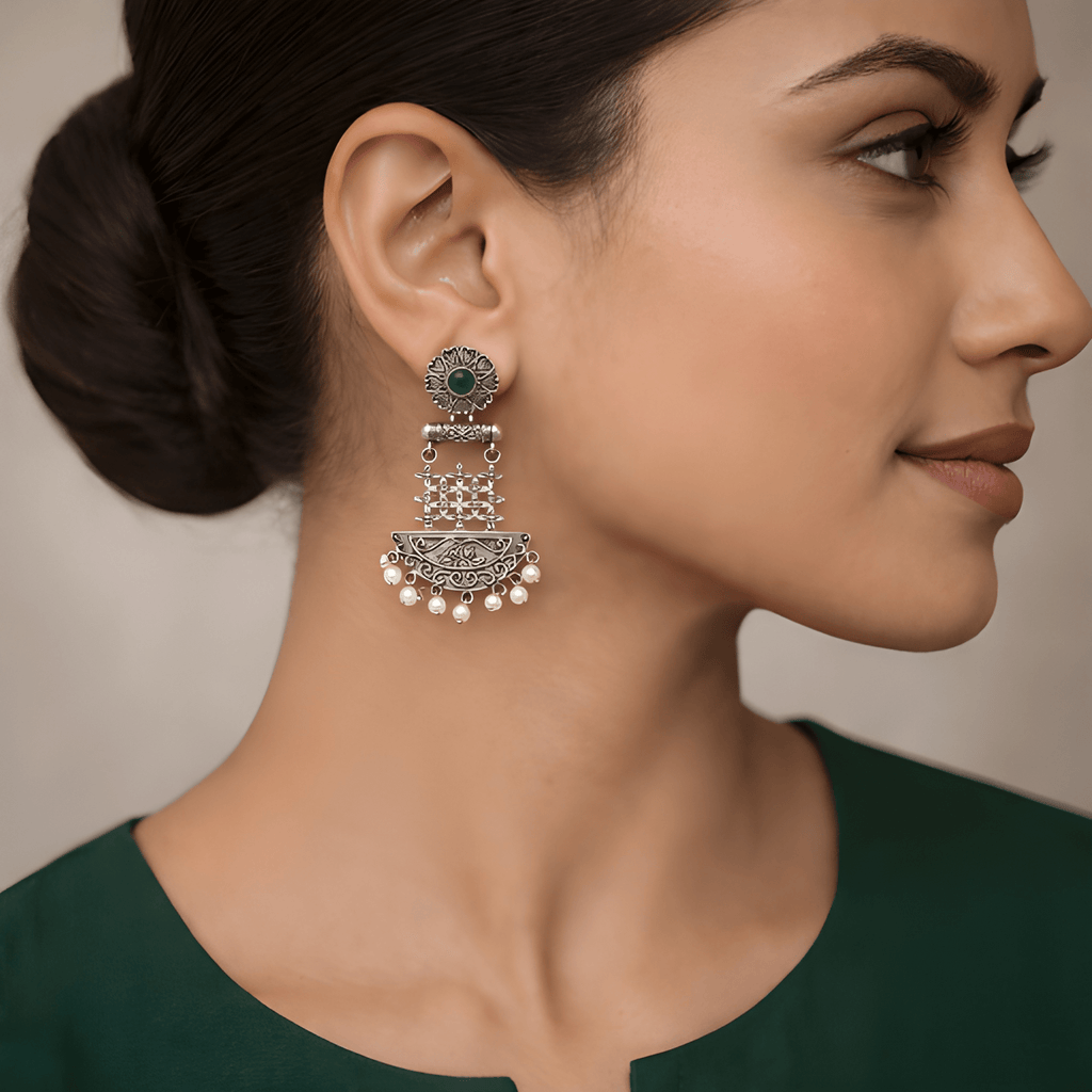 Woman wearing floral lattice chandelier earrings with pearl detailing
