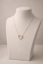 Gold heart pendant necklace displayed on ivory bust stand