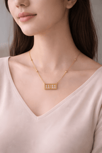 Woman wearing gold 11:11 bar pendant necklace