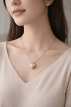 Woman wearing gold heart necklace with delicate stone detail