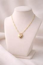 Gold heart pendant necklace with structured bead bar chain on ivory stand