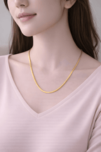 Woman wearing minimal gold snake chain necklace