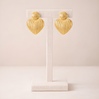 Ribbed gold heart stud earrings on ivory stand