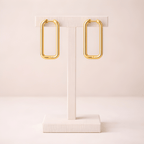 Rectangular gold hoop earrings on ivory stand