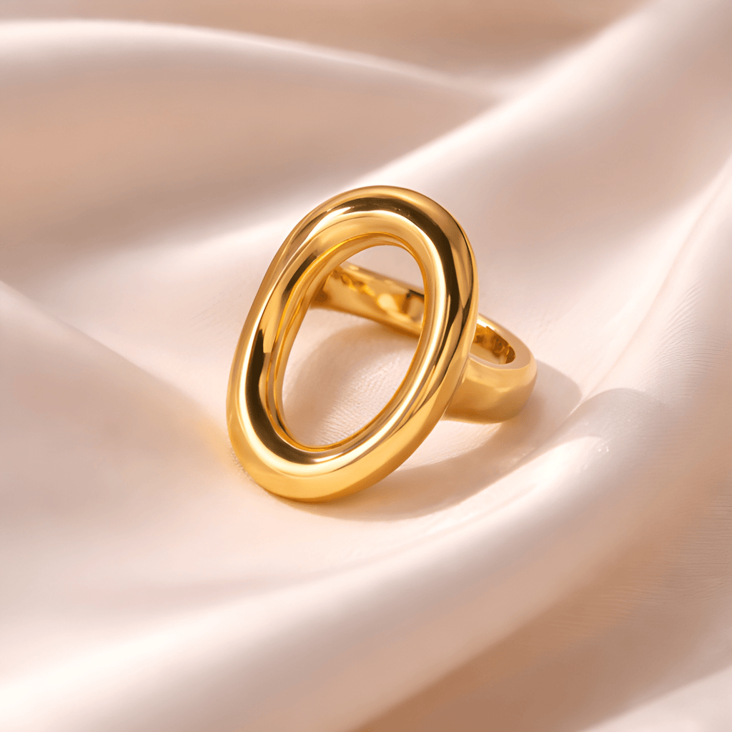 Sculpted oval gold statement ring on blush satin fabric