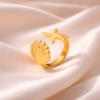 Gold seashell and starfish adjustable ring on blush satin fabric