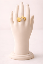 Gold seashell and starfish ring displayed on ivory mannequin hand