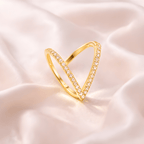 Deep V crystal gold statement ring on soft blush satin background