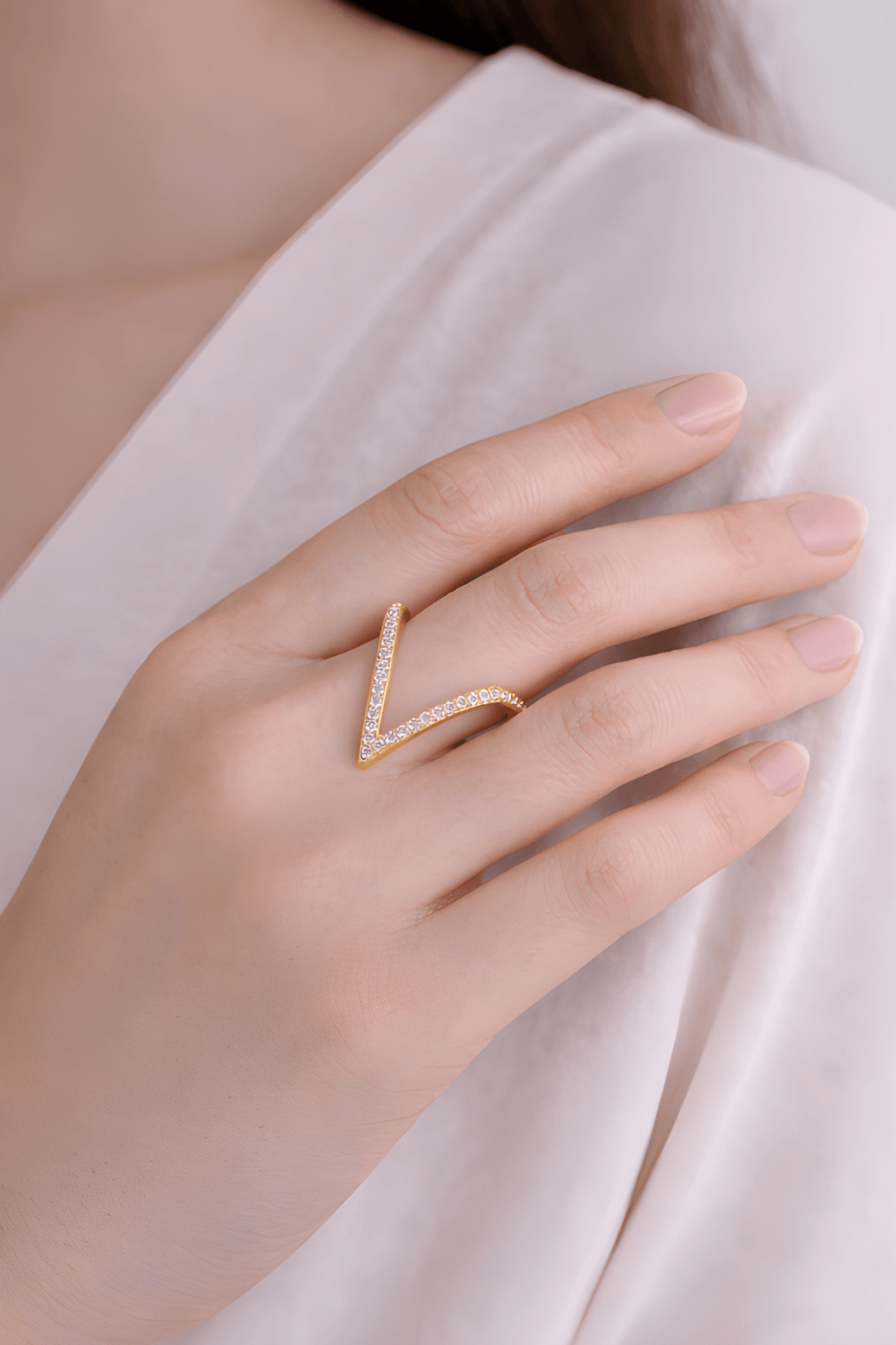 Deep V crystal gold ring worn on woman's finger