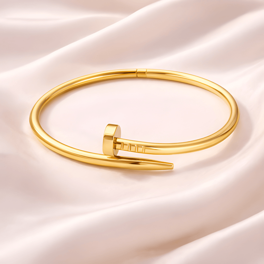 Minimal gold nail bangle bracelet on blush satin