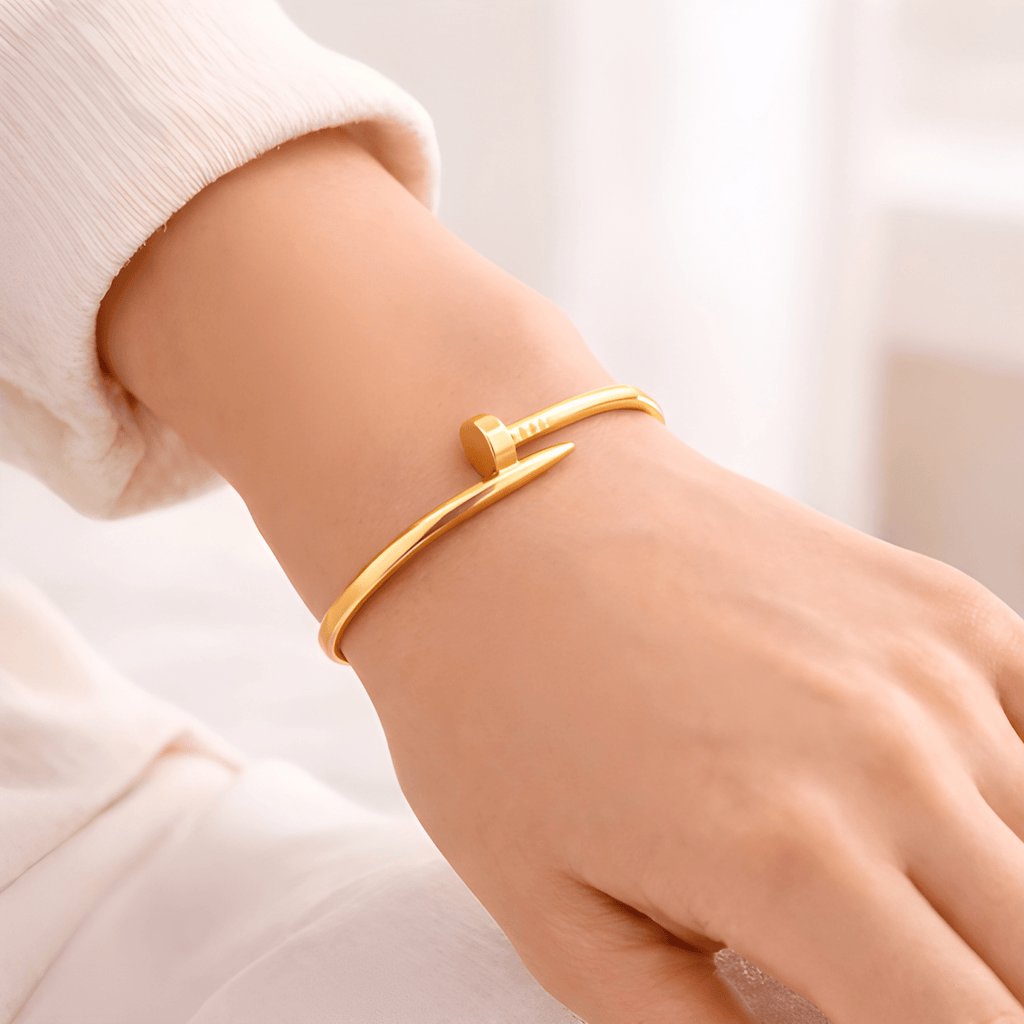Gold nail bangle bracelet worn on woman's wrist