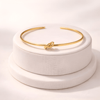 Gold knot cuff bracelet displayed on minimal ivory jewellery stand | Kayahh Jewels