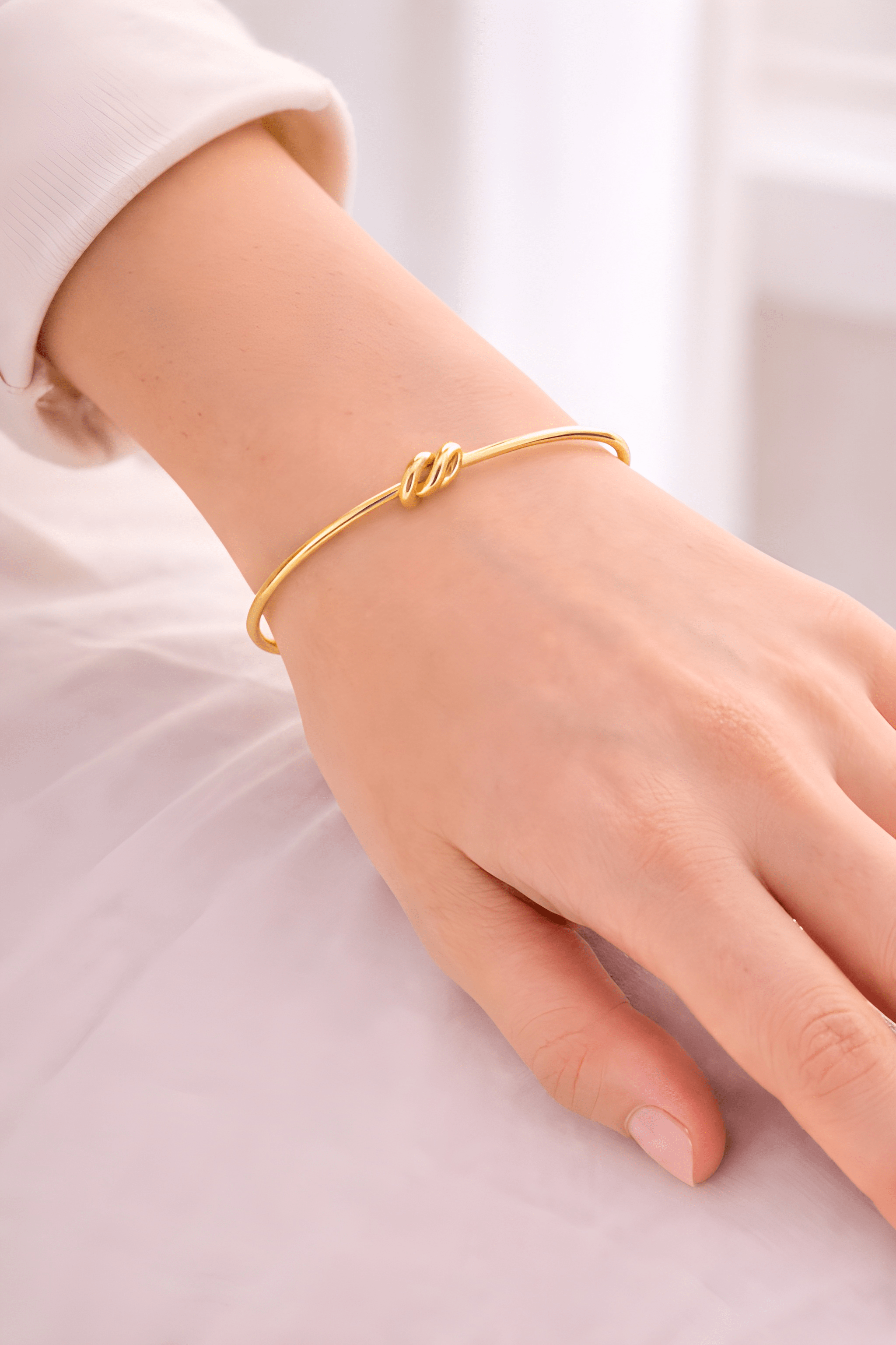 Woman wearing minimal gold knot cuff bracelet on wrist | Kayahh Jewels