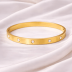 Crystal gold bangle bracelet with diamond style accents on ivory silk background | Kayahh Jewels