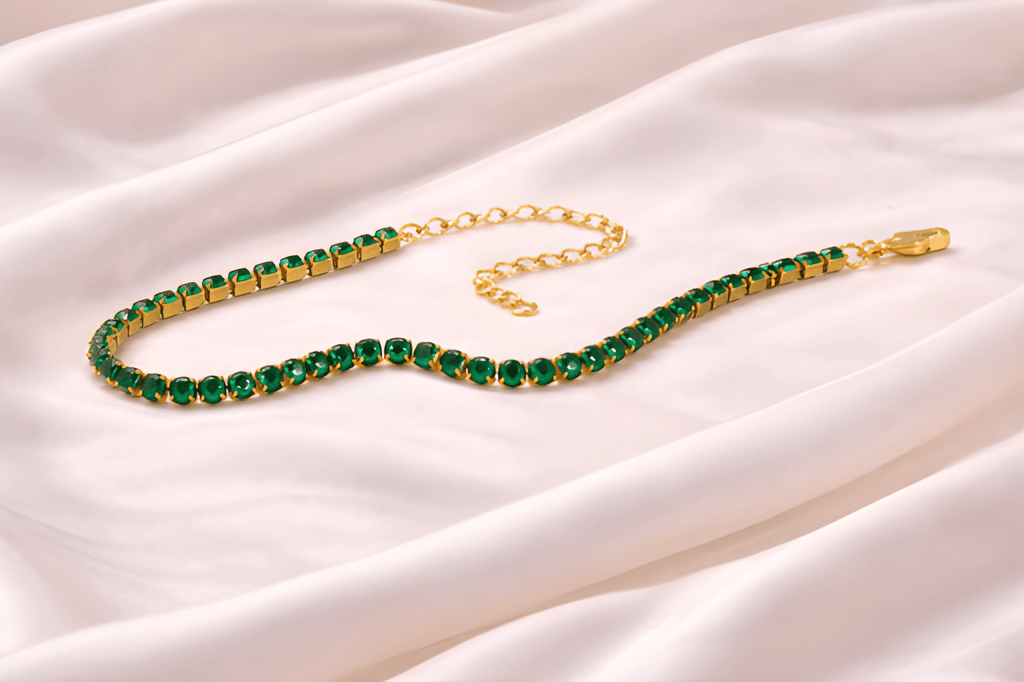 Emerald green tennis bracelet with gold setting on ivory silk background | Kayahh Jewels