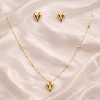 Gold pointed heart pendant necklace with matching pointed heart stud earrings on ivory silk background | Kayahh Jewels