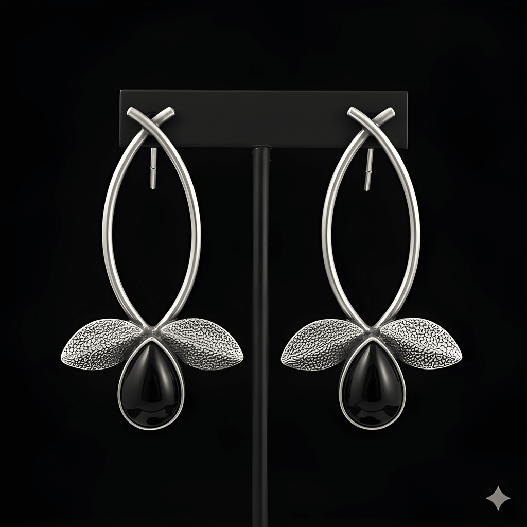 Silver leaf drop earrings displayed on black stand
