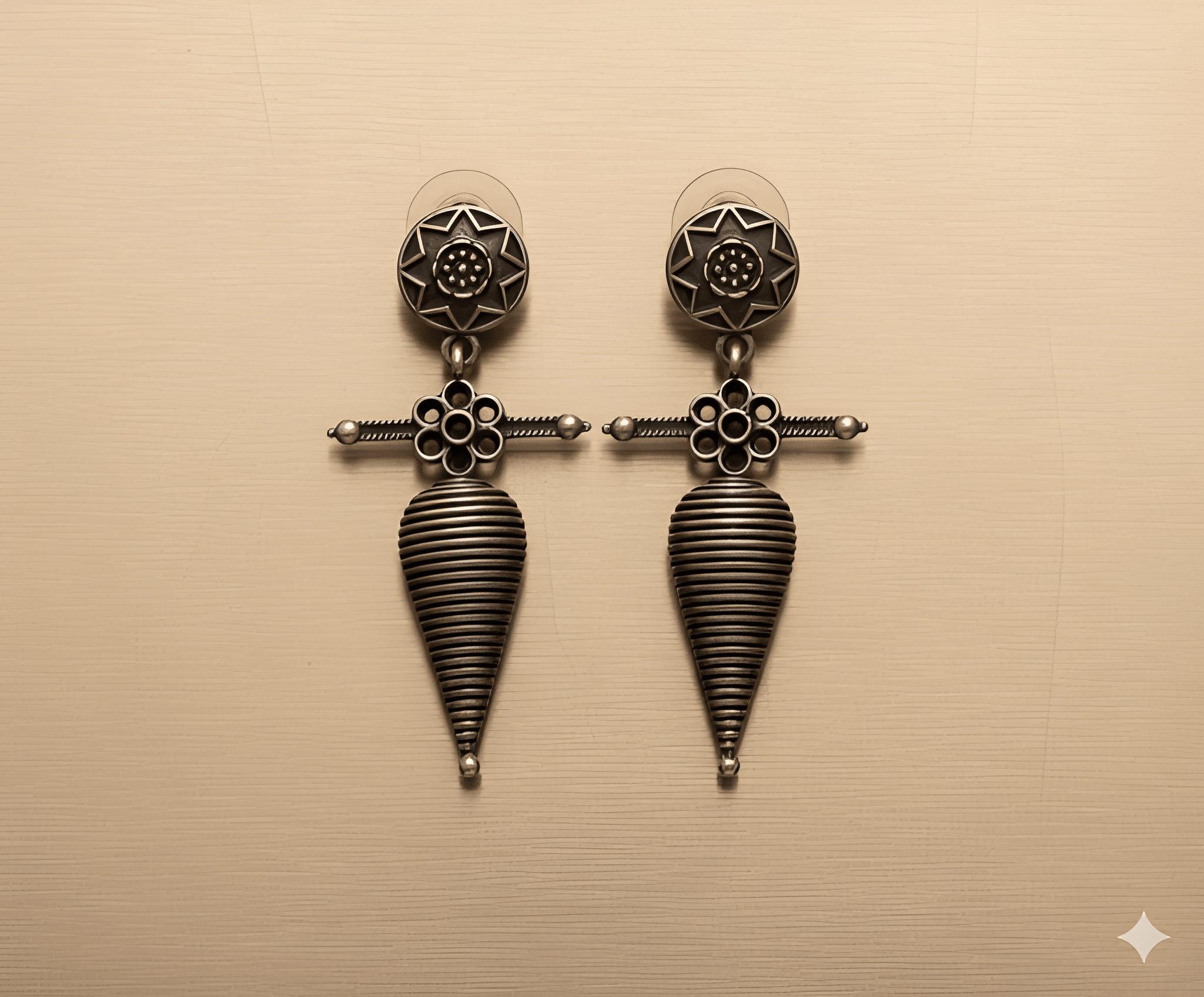 Shell tribal drop earrings with oxidised silver finish on golden background
