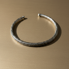 Handcrafted oxidised silver minimal hasli neckpiece on golden background
