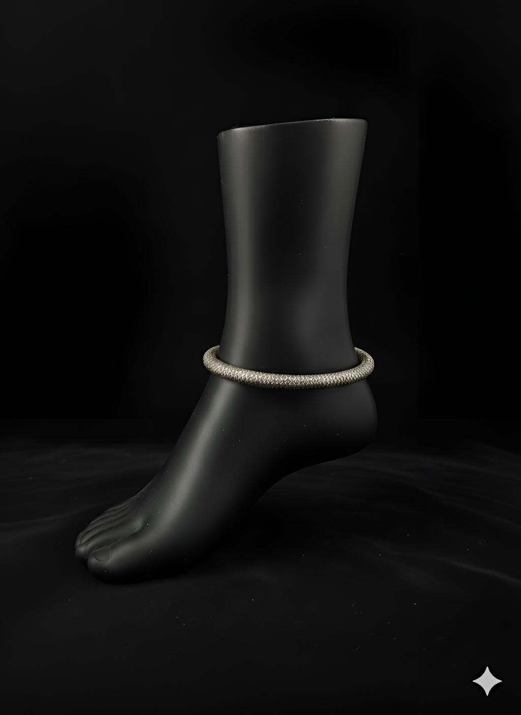 Textured handcrafted brass anklet displayed on black stand
