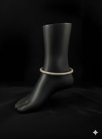 Textured handcrafted brass anklet displayed on black stand
