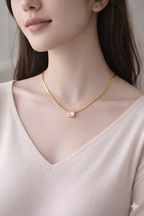 Woman wearing gold rectangle blush pink stone pendant necklace
