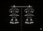 Handcrafted spiral jhumka earrings displayed on black stand
