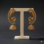 Peacock gold jhumka earrings on ivory stand