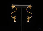 Gold S-shaped vine curve earrings displayed on black stand
