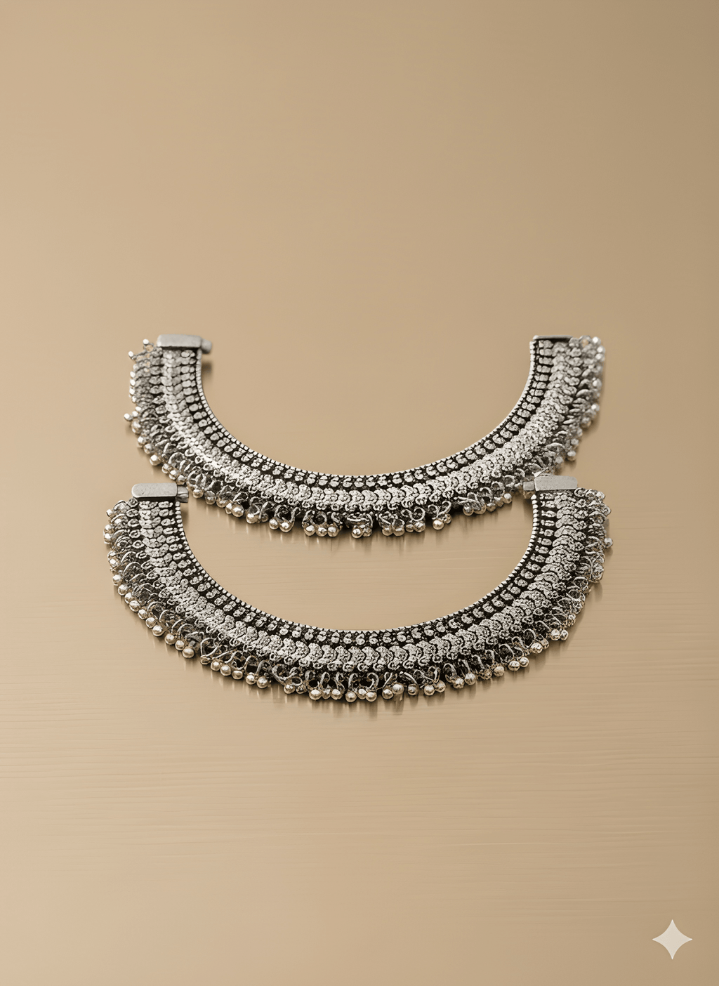 Handcrafted oxidised silver heavy karigari anklet pair on golden background
