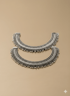 Handcrafted oxidised silver heavy karigari anklet pair on golden background
