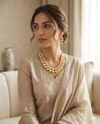 Woman wearing traditional gold Kundan necklace set with pear stones