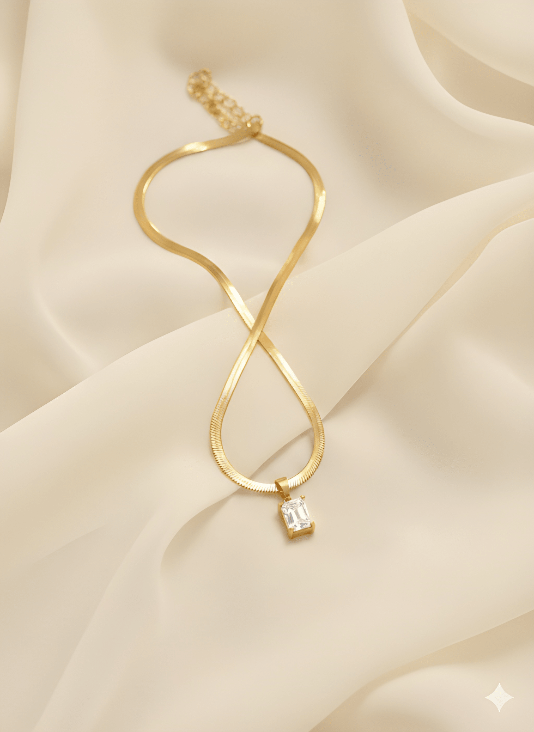 Gold rectangle pendant necklace with clear crystal stone on ivory fabric