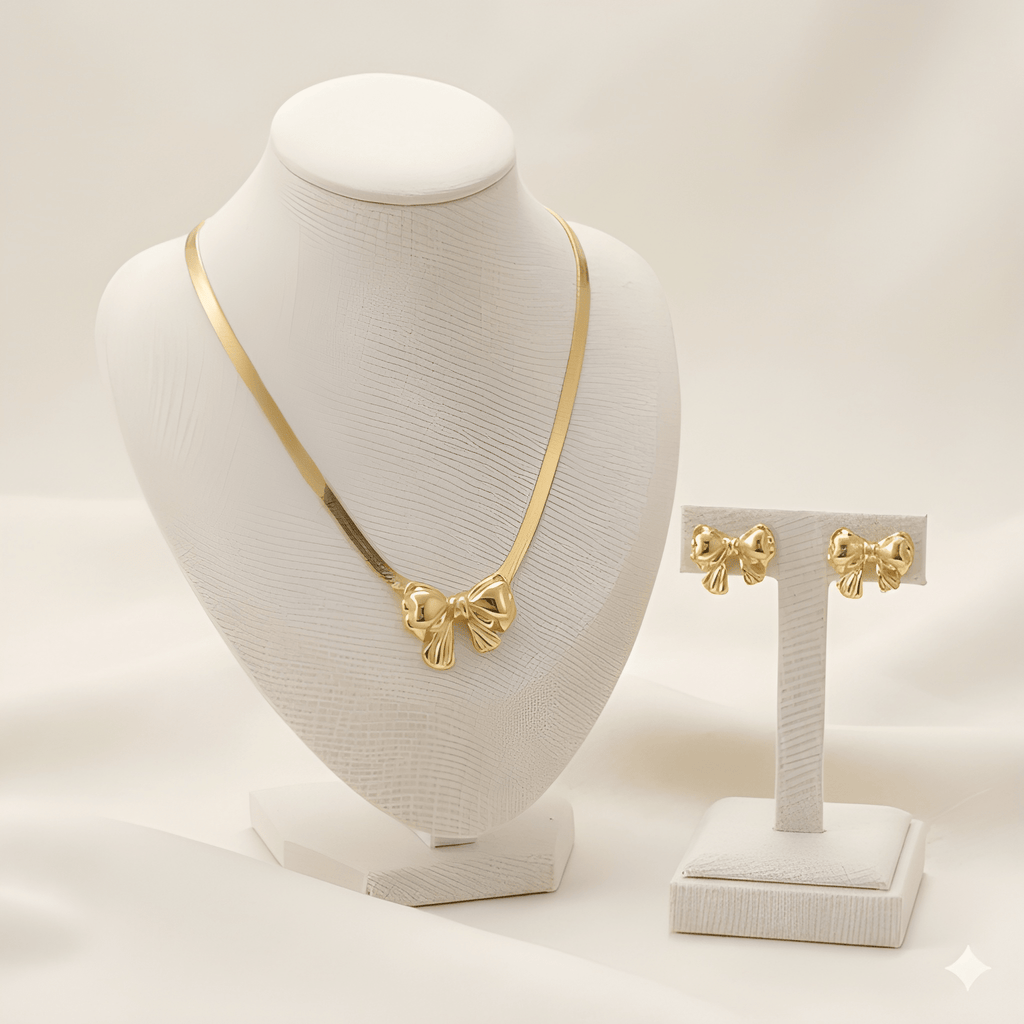 Gold bow pendant necklace set with matching bow stud earrings on ivory jewellery stand | Kayahh Jewels