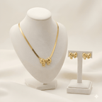 Gold bow pendant necklace set with matching bow stud earrings on ivory jewellery stand | Kayahh Jewels