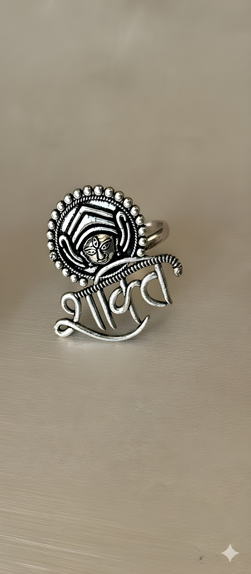 Shakti motif oxidised silver statement ring with sculpted detailing on golden background