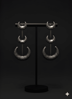 Chandra crescent statement earrings displayed on black stand in dark antique finish
