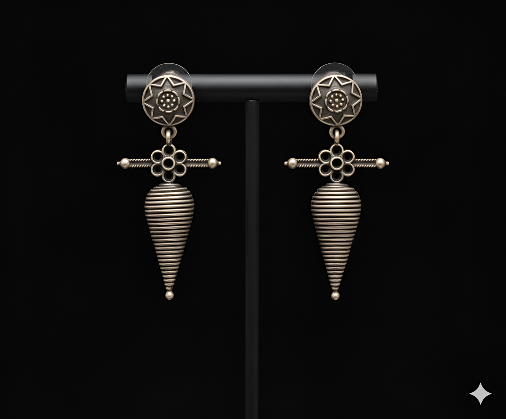 Shell inspired tribal drop earrings displayed on black stand
