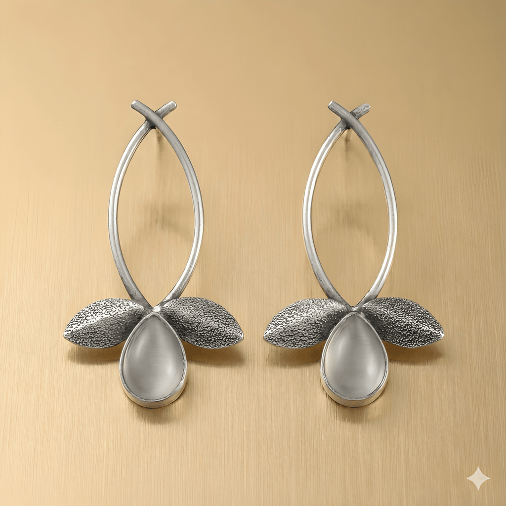 Leaf drop earrings with teardrop stone on golden background
