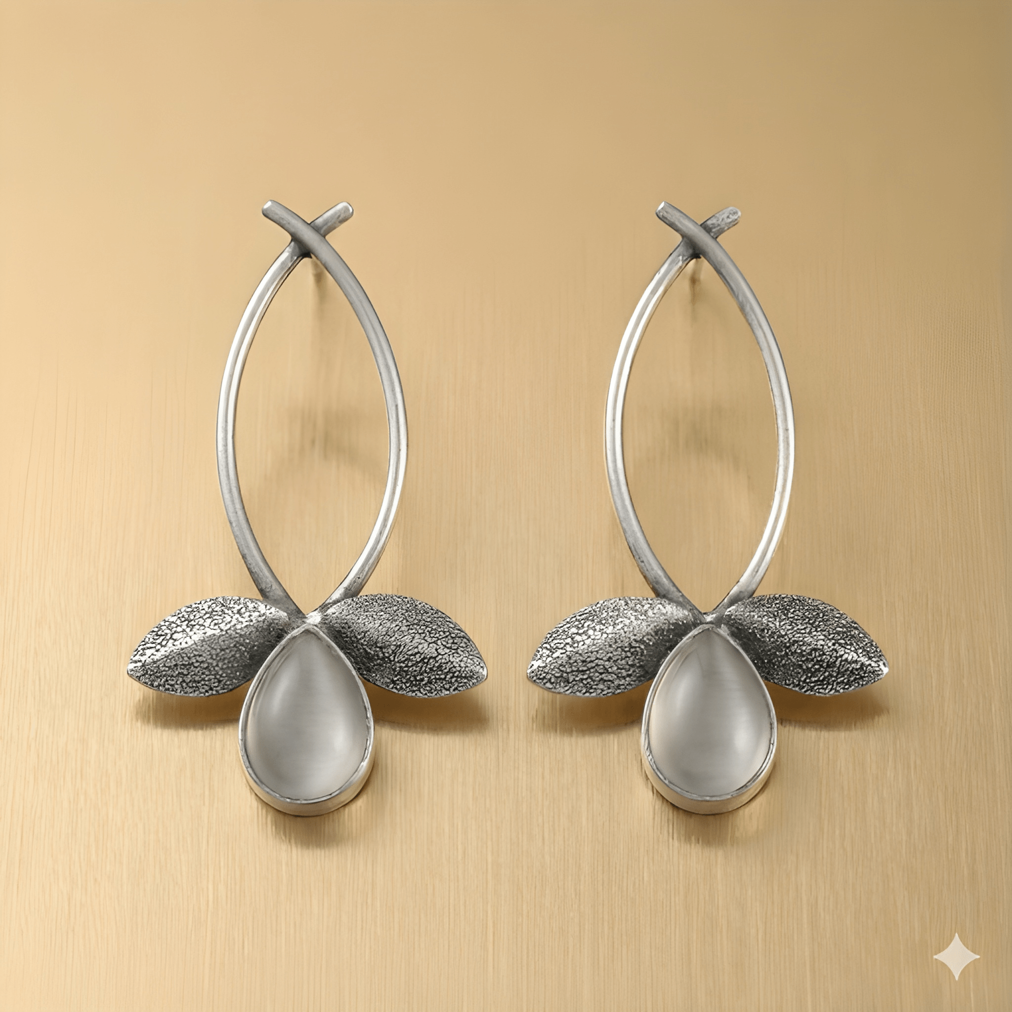 Leaf drop earrings with teardrop stone on golden background
