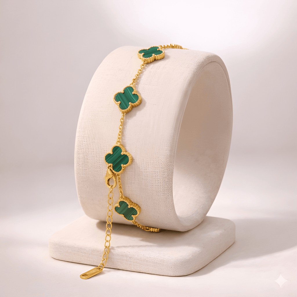 Emerald green clover bracelet displayed on ivory stand