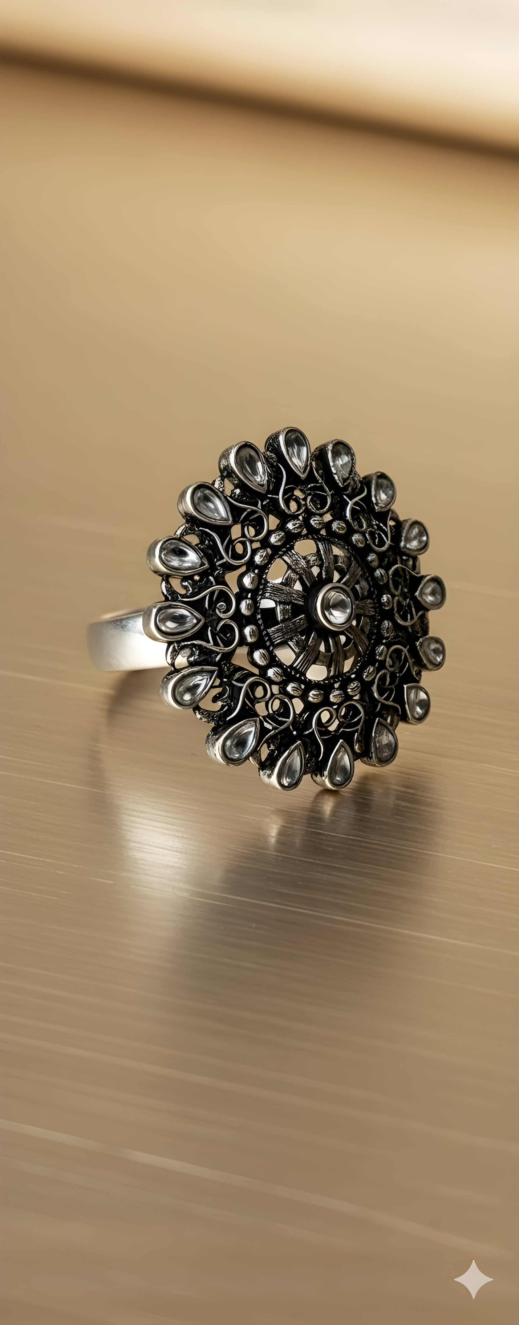 Teardrop detail oxidised silver statement ring on golden background