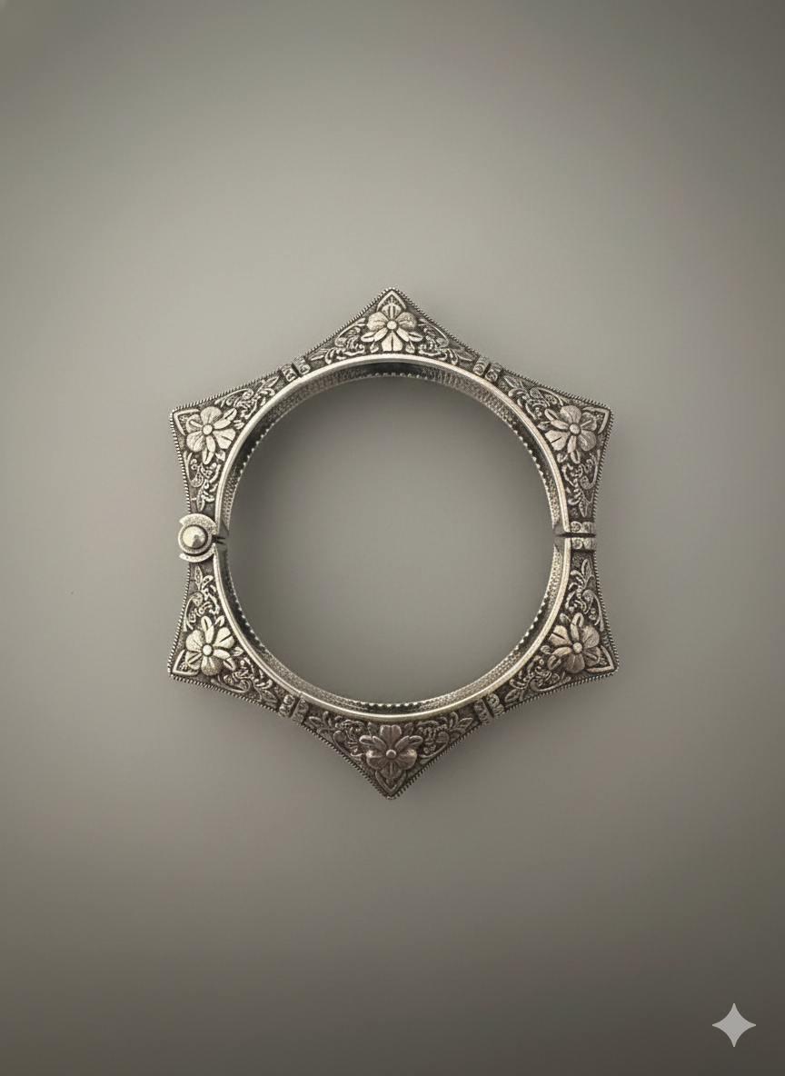 Top view close-up of floral engraved detailing on handcrafted oxidised silver cuff bracelet
