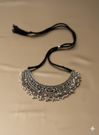 Handcrafted oxidised silver pearl choker neckpiece on golden background
